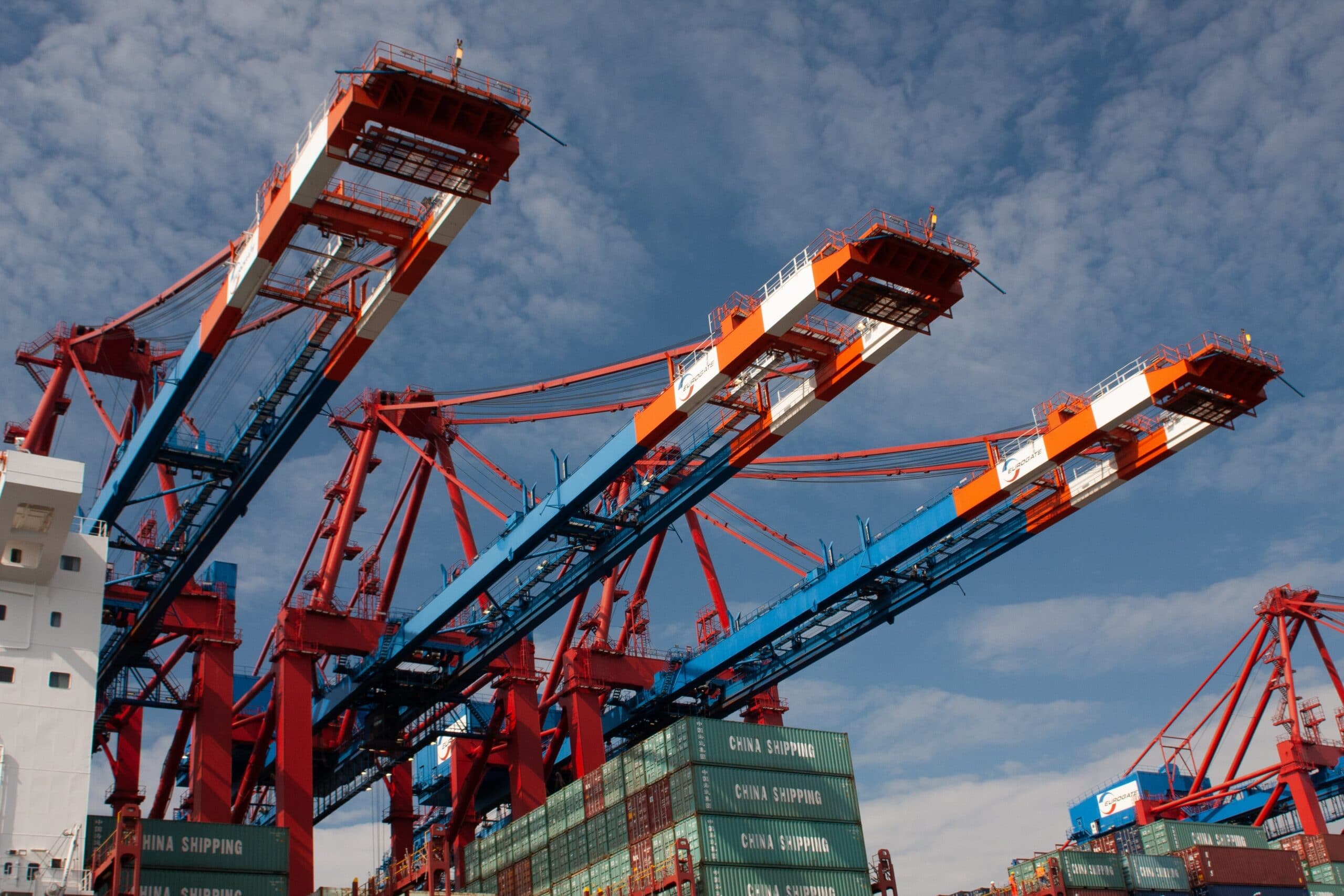 image of cranes hanging over shipping containers